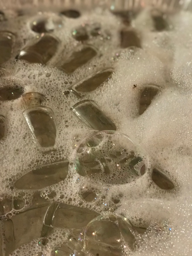 cleaning dirty bottles soapy water